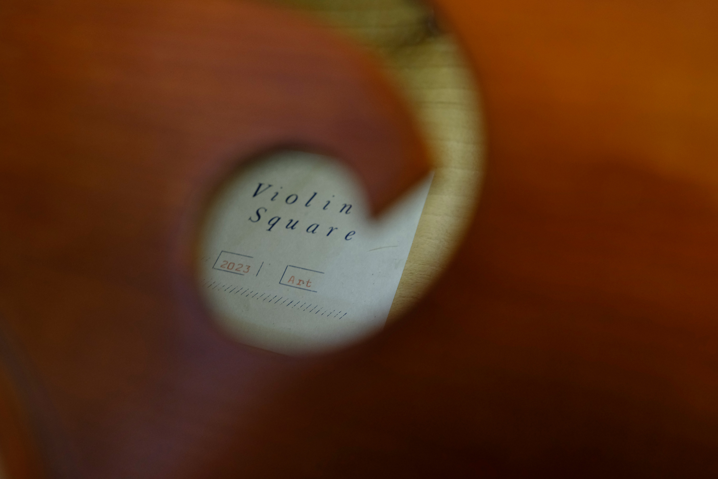 Blick durch f-Loch eines Instrumentenkorpuses. Label mit Beschriftung im Inneren des Korpuses.