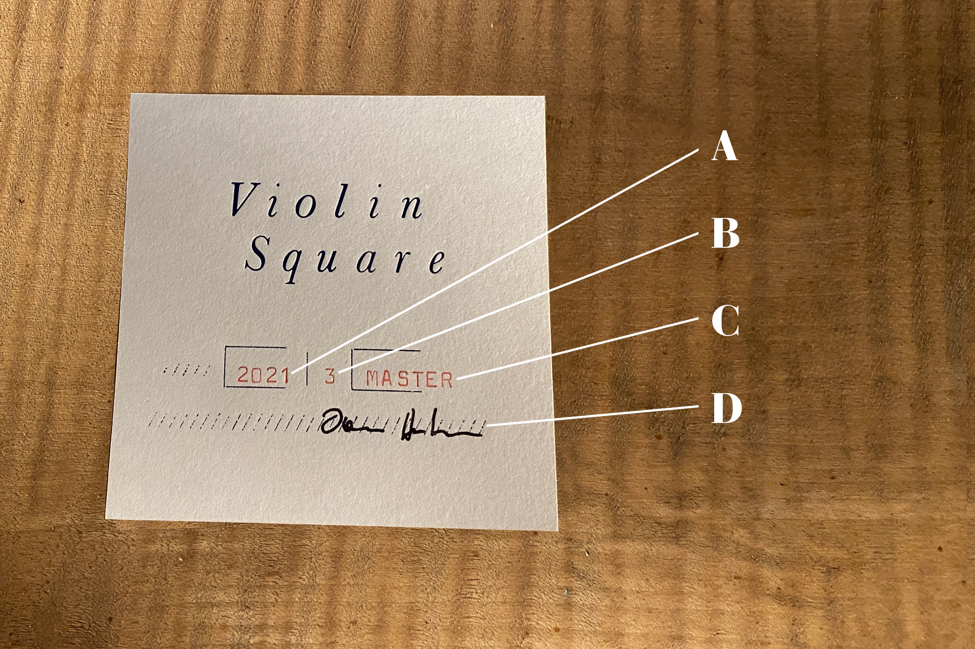Label aus Papier mit Logo, Jahr der Fertigstellung, Kategorie, Qualitätsstufe, und Signatur des Geigenbaumeisters. 